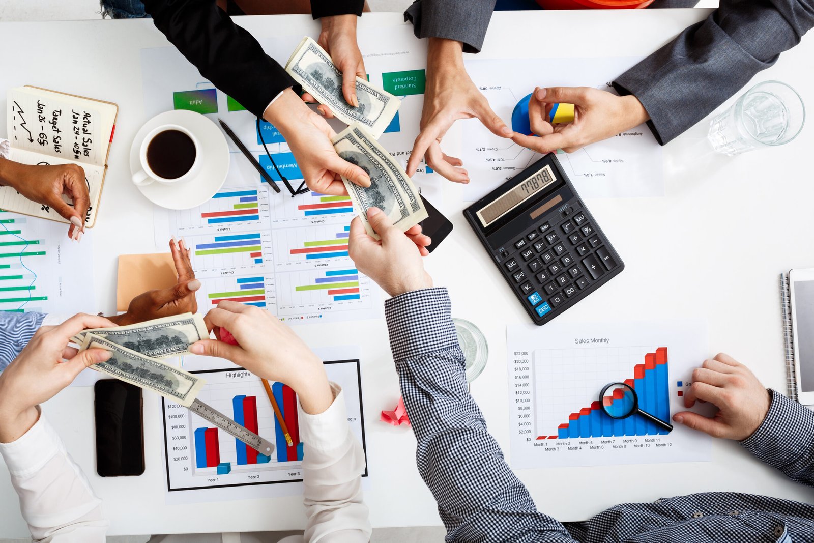 Picture of businessmen's hands on white table with documents and drafts